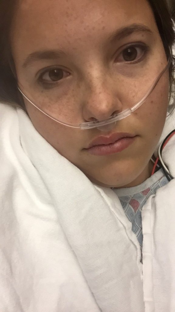 woman wrapped in a white blanket with an oxygen tube in her nose