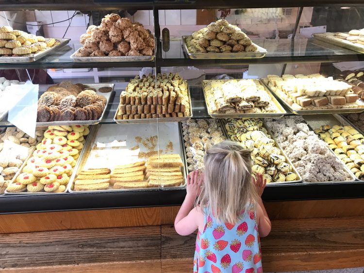 the author's daughter looking at cookies through the store window