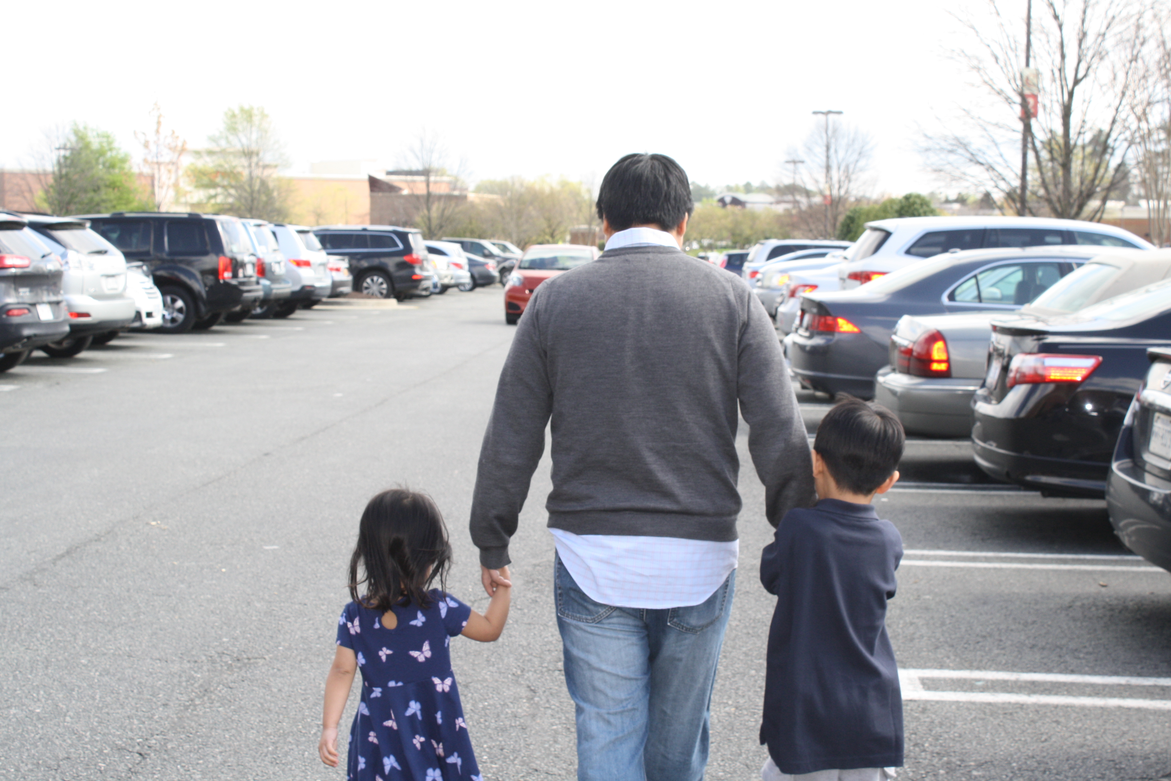 dad with his two kids in a parking lot