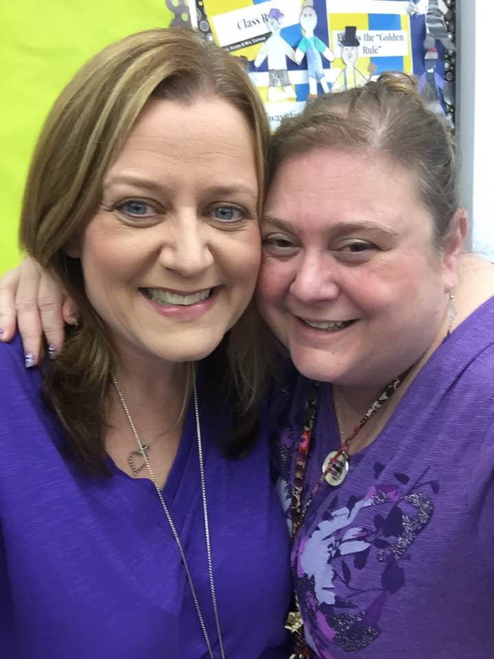 two women wearing purple shirts