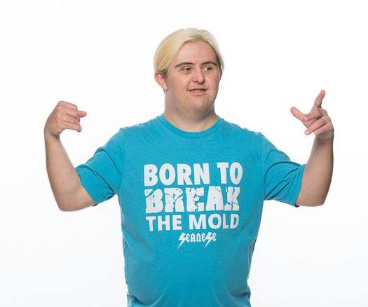 Sean wearing a teal short that says: born to break the mold