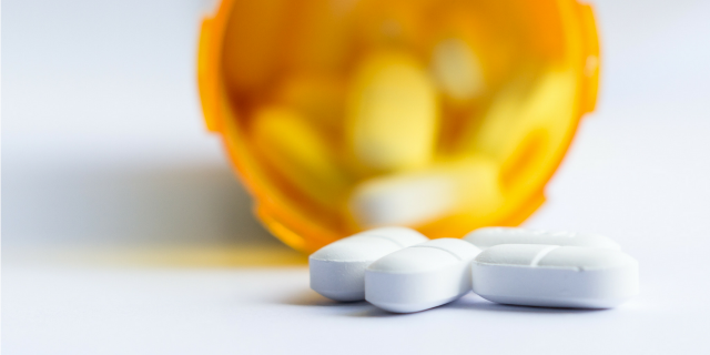 Incoming NRA President Oliver North Blames Ritalin for School Shootings After Santa Fe High School Shooting A pill bottle is on its side with three pills laying on the table outside of the bottle.