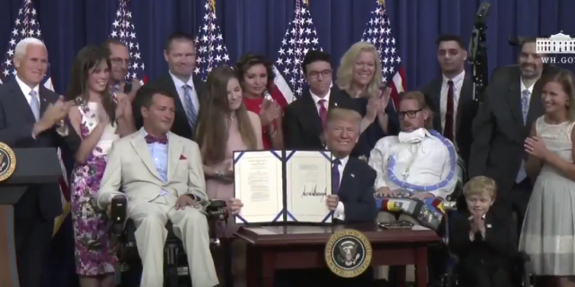 President Trump Signs 'Right to Try' Legislation Allowing Patients Access To Unapproved Drugs Image of Trump signing right to try bill. He is surrounded by children and adults with terminal illnesses and disabilities.