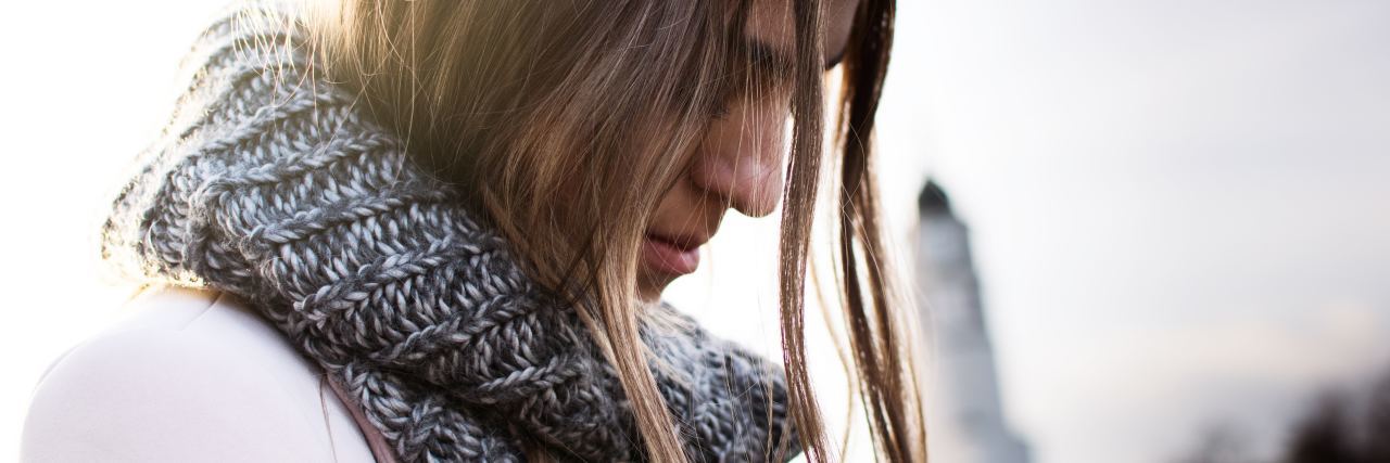 When Others Expect Me to Always Be Strong in Life With Chronic Illness woman wearing a scarf and looking down