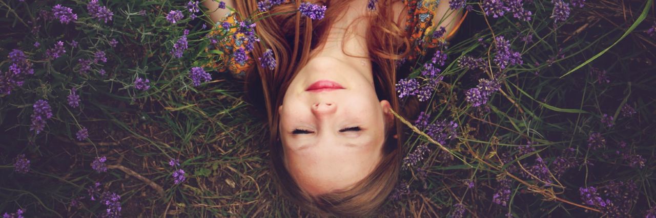 woman laying in a bed of purple flowers