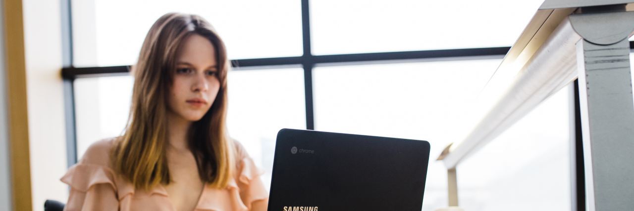 Why I'm Honest About My Invisible Illnesses blond woman at her computer