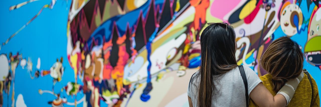 9 Ways to Support Someone in Eating Disorder two women standing in front of street art laughing with arms around each other