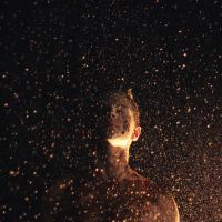 woman surrounded by raining golden glitter