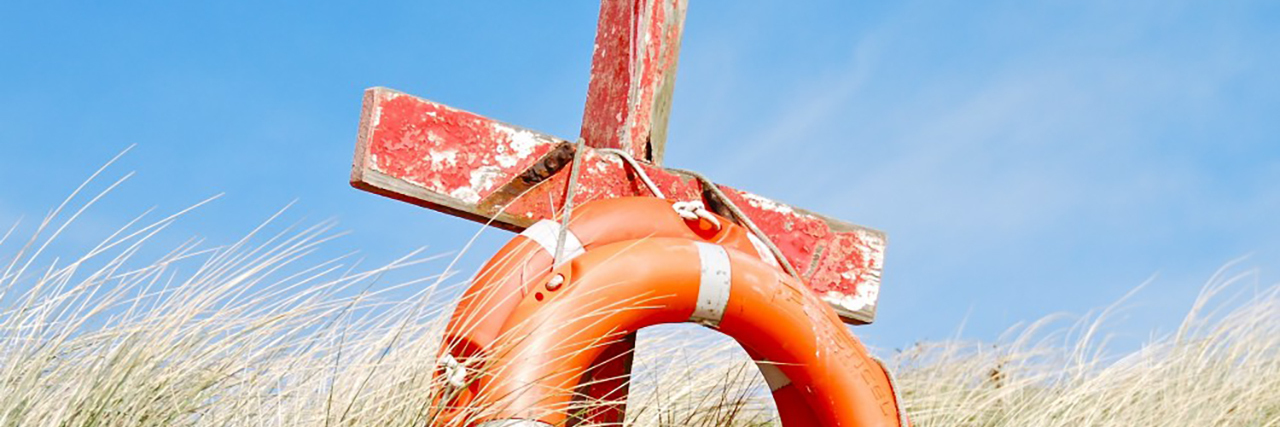 Finding Healing From Abuse and Mental Illness as Someone With Autism Cross and life preserver in a field.