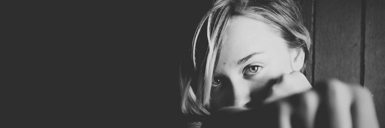Little Motivation Tricks for Getting Through the Day With Depression black and white photo of woman holding out fist motivation for depression