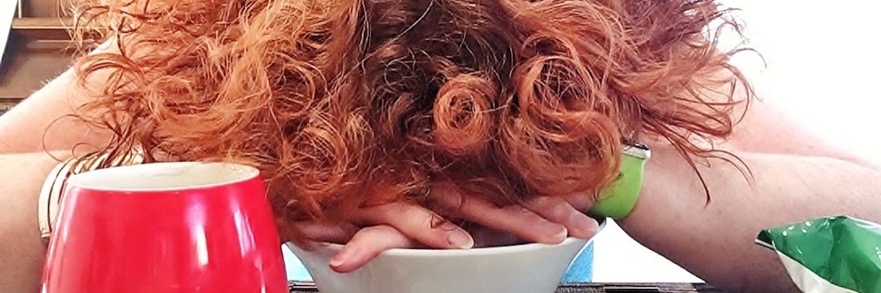 A picture of the writer, with her head down on the kitchen table - only showing her red hair.