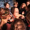 Gaelynn Lea playing violin with a group of young students.