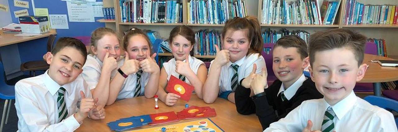 'Everybody's Different' Teaches Kids About Differences in a Fun Way Group of kids giving thumbs up around a table with the game
