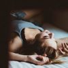 woman lying in bed alone looking at window