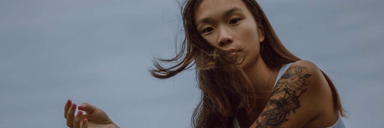 Reminders About Healing From Trauma A woman sitting in front of a stormy sky