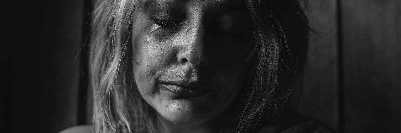 black and white high contrast photo of young woman crying