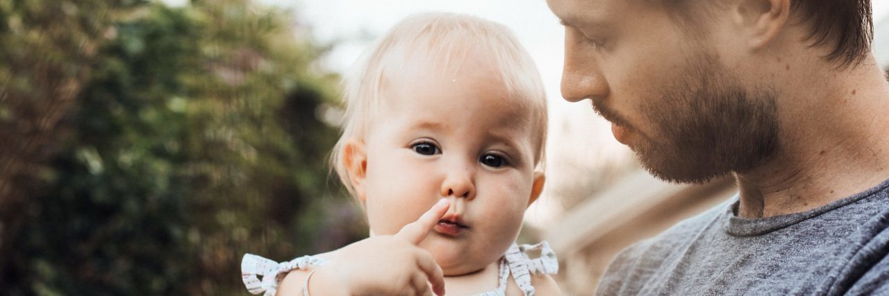 The Truth About Postpartum Depression in Fathers father and young baby in nature near hedge