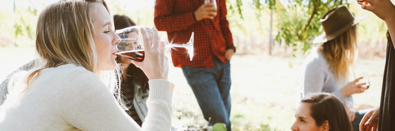 10 ‘Ugly’ Truths of Social Anxiety young woman in social setting drinking wine anxiety