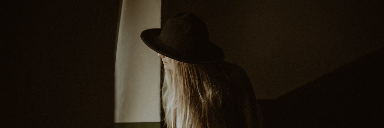 6 Complex PTSD Triggers — and 6 Things That Help woman with hat looking around the corner