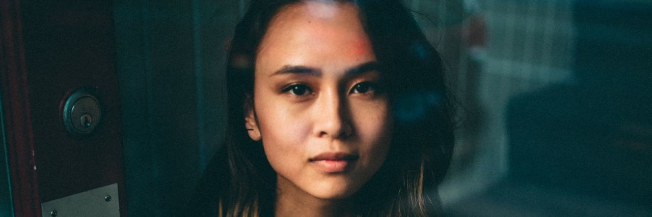 How Online Therapy Can Help People With Social Anxiety asian woman sitting in dark room