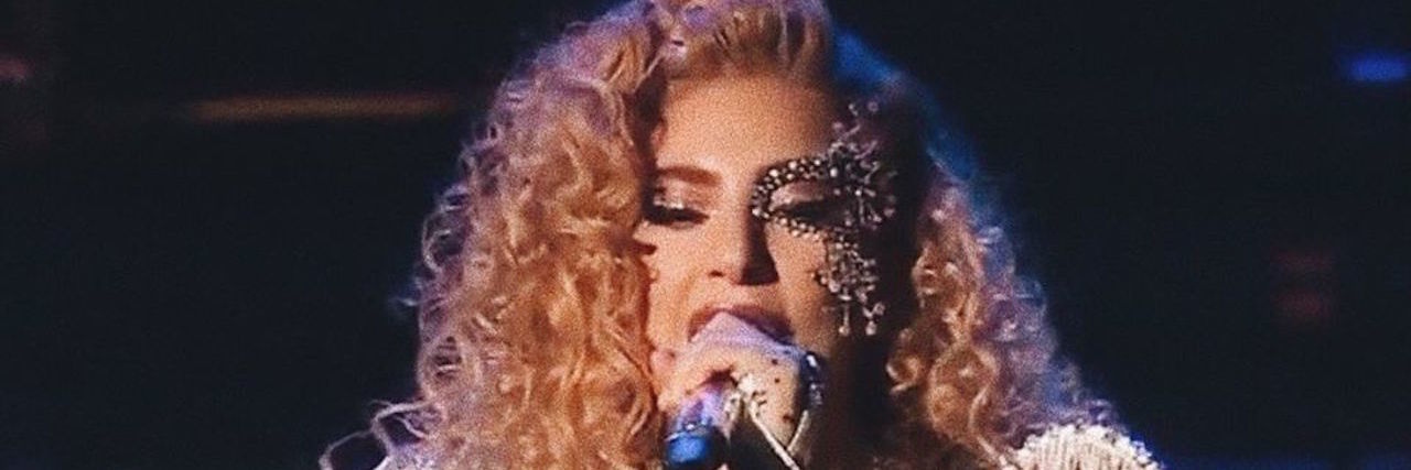 'Joanne' Made Me Cry When Lady Gaga Opened Up About Her Fibromyalgia A picture of Lady Gaga singing into a microphone from stage.