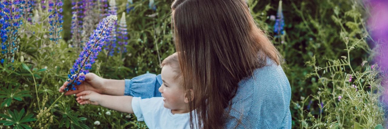 Why I Talk to My Kids About My Bipolar Disorder mother and son in meadow of purple flowers