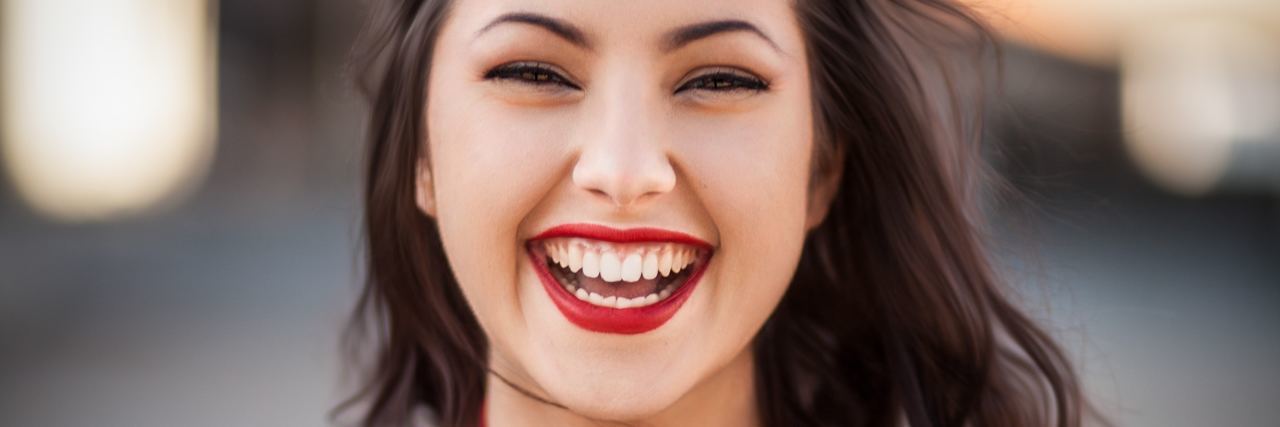 Why I Actually ‘Like’ My Bipolar Disorder young confident woman smiling and laughing into camera