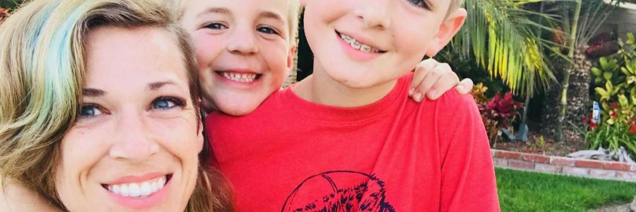 Single Moms With Depression Deserve to See Themselves Differently Moms selfie with her two boys, they are all smiling at the camera. Her boys are little kids.