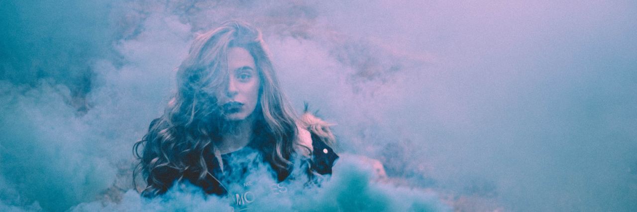 woman surrounded by blue smoke