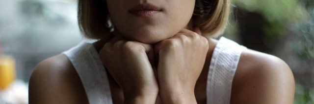 close up portrait of woman with short hair resting on hands