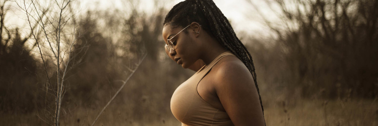 What It's Like to Hear 'Worrying Is a Sin' as a Christian With Anxiety woman looking down in field