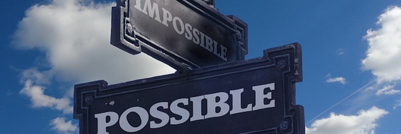 street signs: one saying "possible," and one saying "impossible"