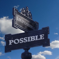 street signs: one saying "possible," and one saying "impossible"