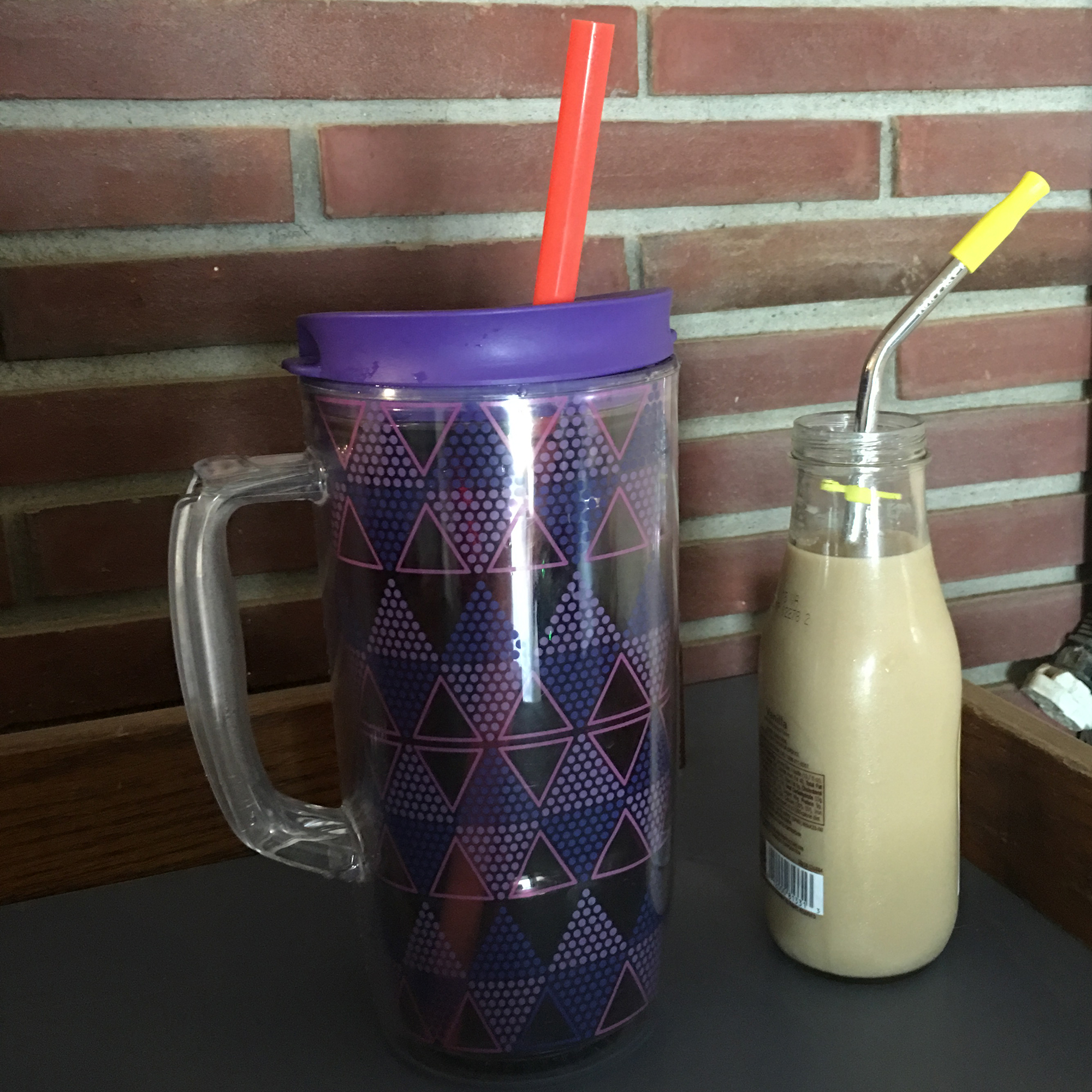 Disability friendly reusable straws in cups. Left, silicone and right, metal with silicone tip,