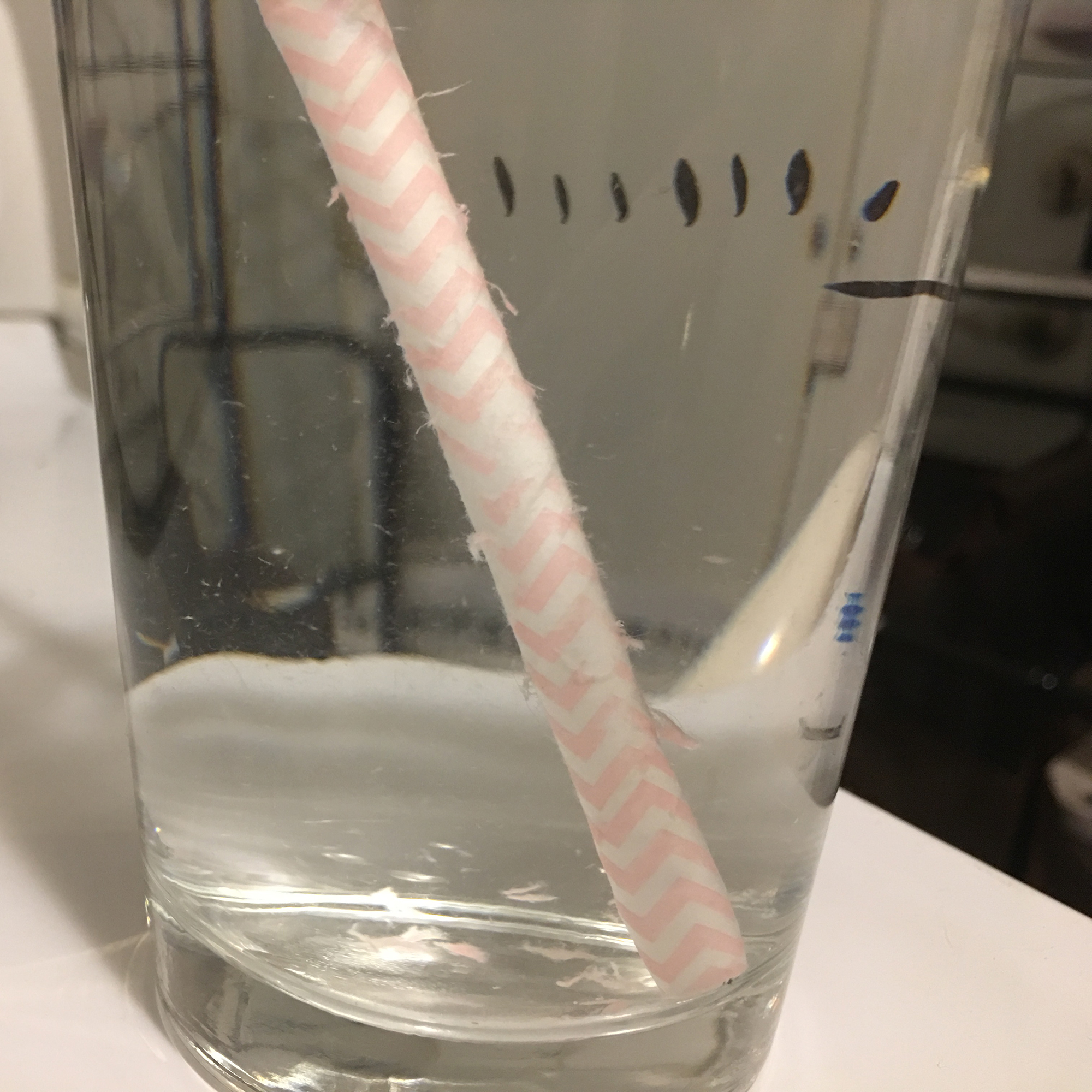 Paper straw dissolving in a glass of water.