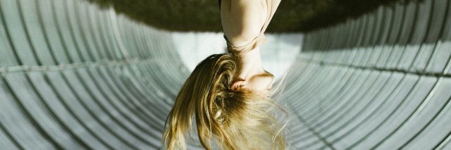 upside down photo of woman with blonde hair in tunnel
