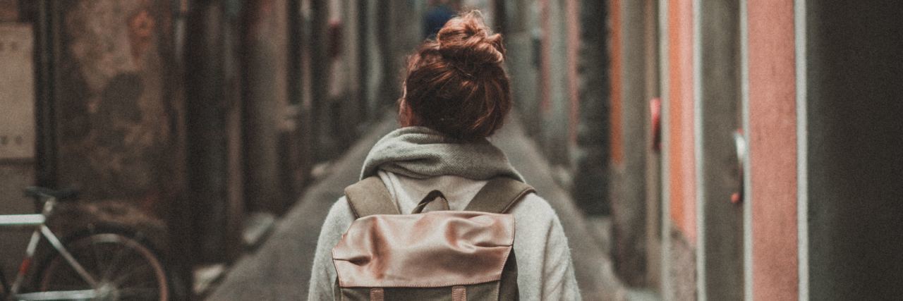 Tips for Traveling When You Live With Bipolar Disorder young woman walking down alleyway while traveling