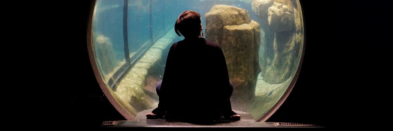 What It’s Like to Come Out of Depression young woman looking through bubble window in zoo with penguin