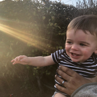 the author's son smiling, with light shining on him