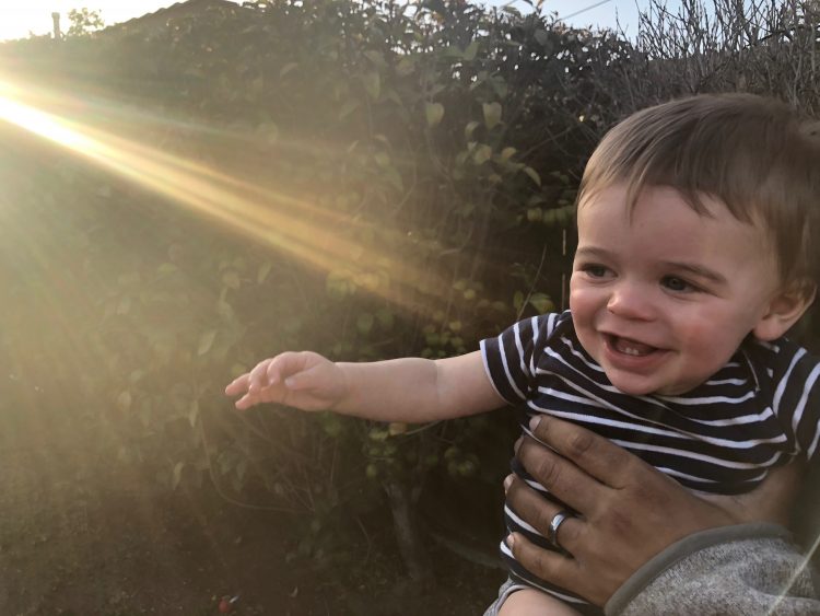 the author's son smiling, with light shining on him