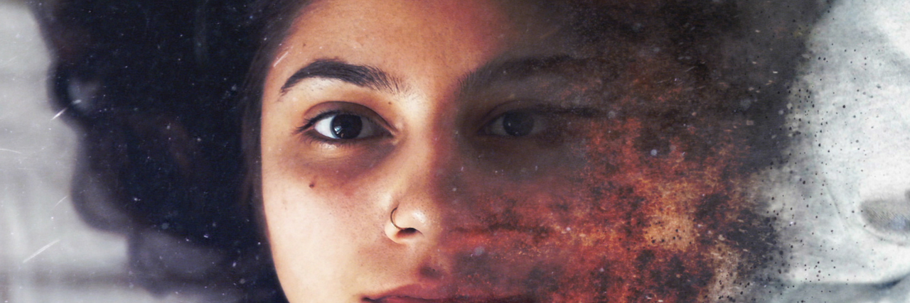 11 'Harmless' Comments Partners Say That Can Be Emotionally Abusive woman laying on bed with face turning into fire