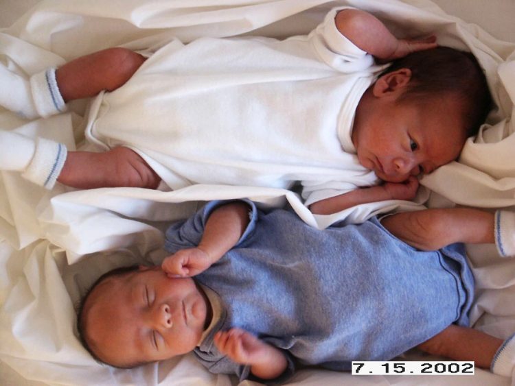 Twin babies, laying side by side head to toe
