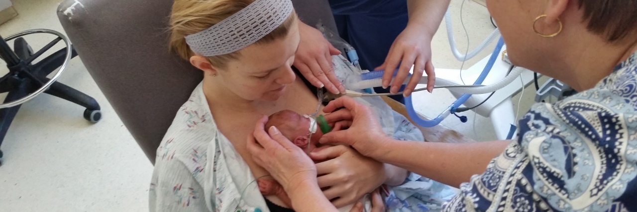 Dear Son, Your Story Starts Here Mother holding preemie baby for first time, two nurses' hands visible as they help with the monitors, wires, and support for baby