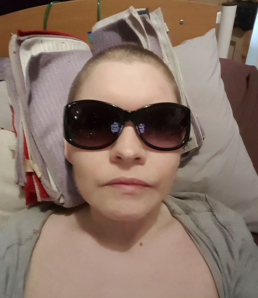 woman lying in bed wearing sunglasses