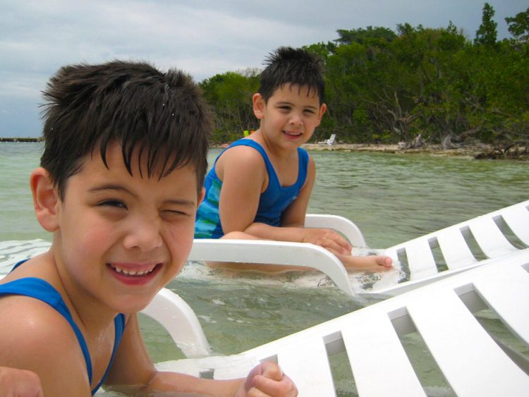 Twin boys enjoying water play activity in a lake