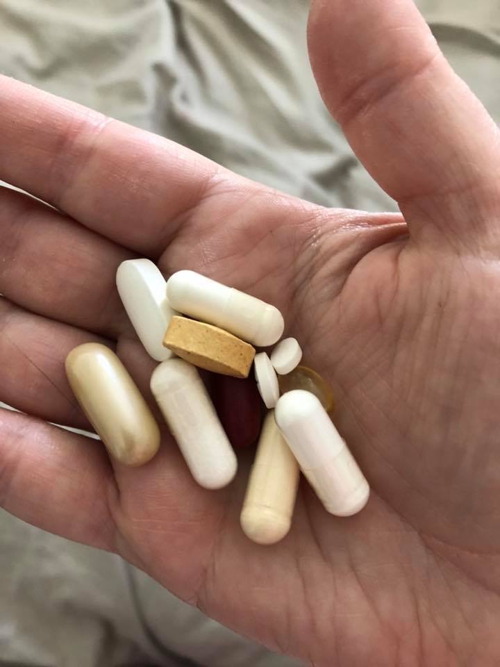 woman holding handful of pills