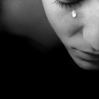 A black and white image of a woman crying.