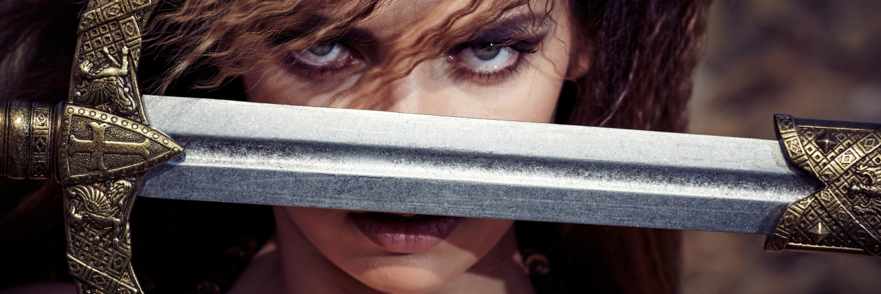 Brain Injury Made Me a Badass Warrior woman holding a sword.