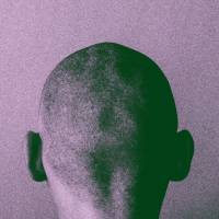 A man looking towards a wall, the back of his head to the camera, with a purple overlay.