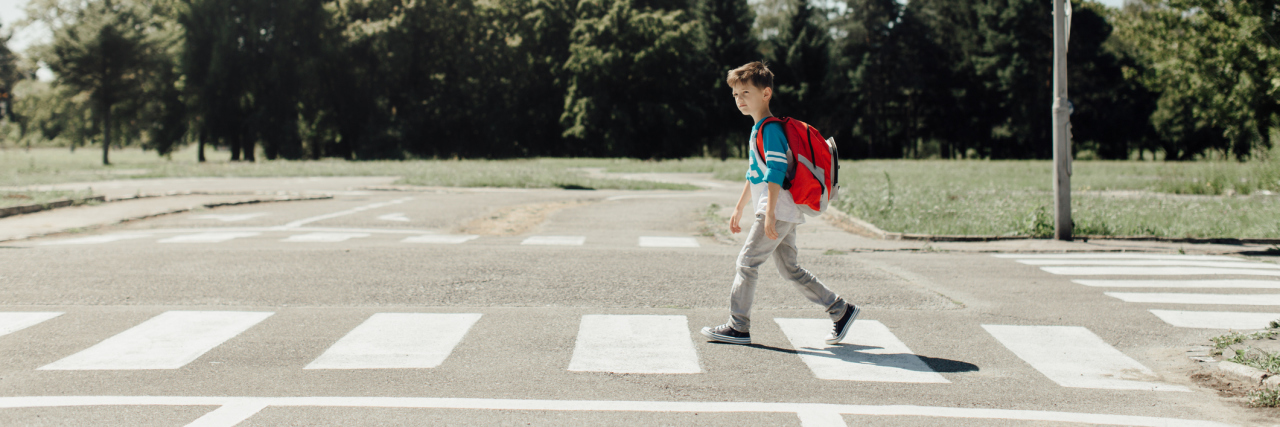 Why We Chose to Send Our Child With Autism to a Therapeutic School Boy at school crossing with backpack